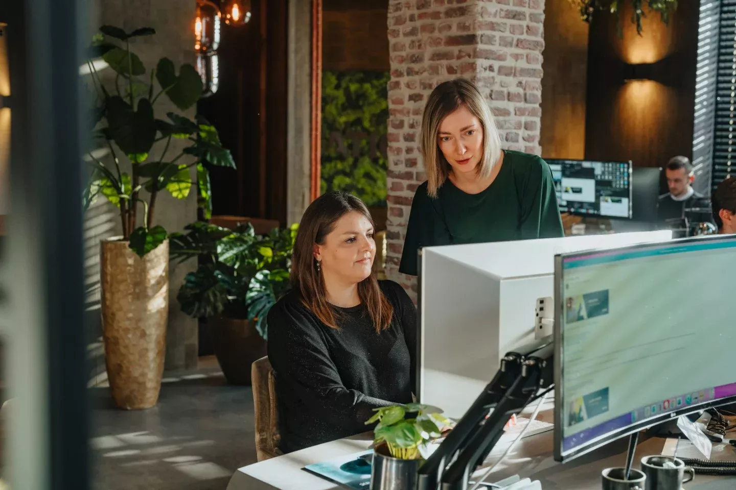 Twee collega's bespreken nieuwsbrief strategie en email marketing resultaten