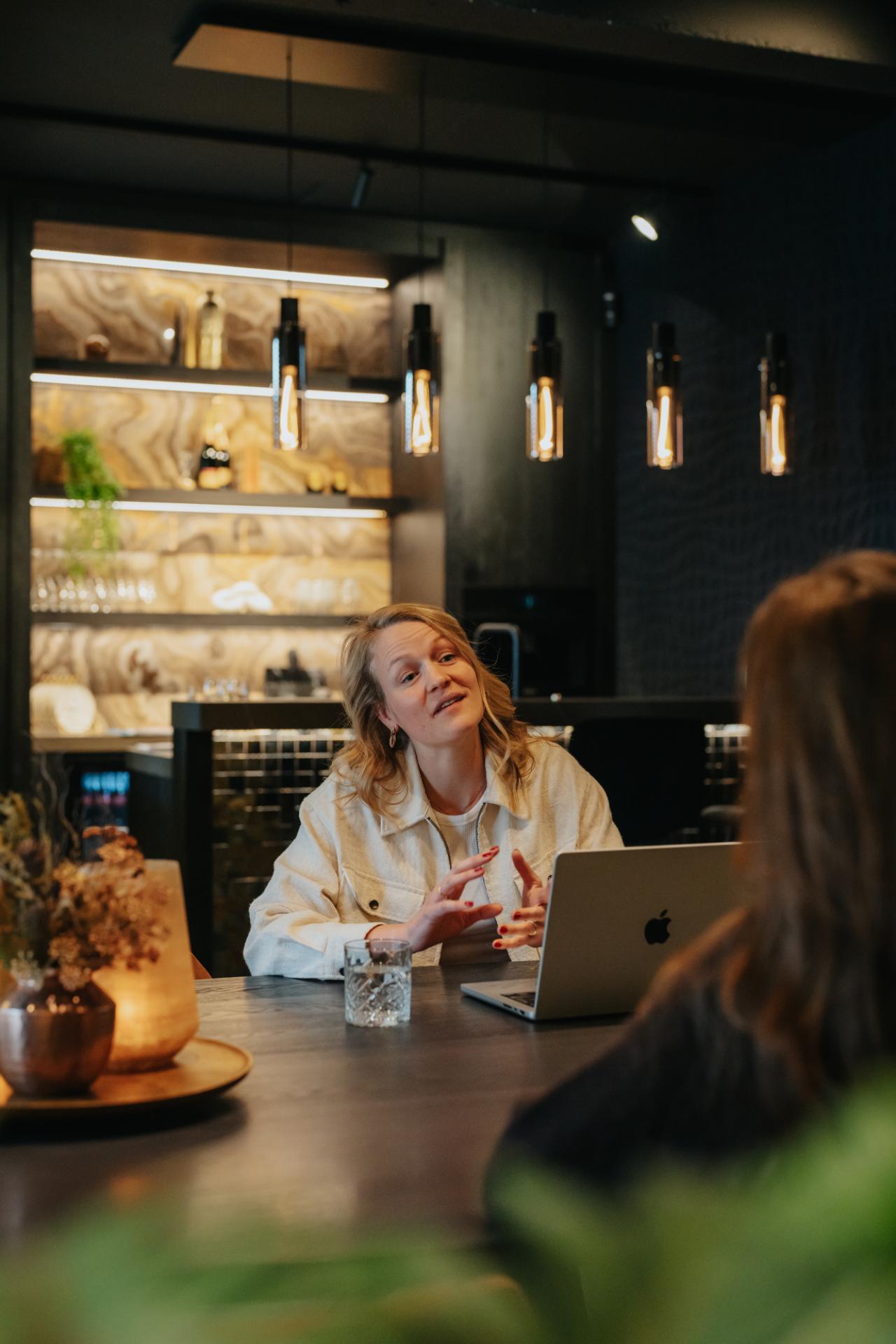 Overleg over website strategie met klant en laptop